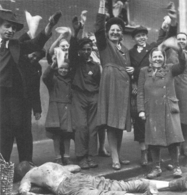 Czech civilians greet the Americans marching in, at their feet a slew German